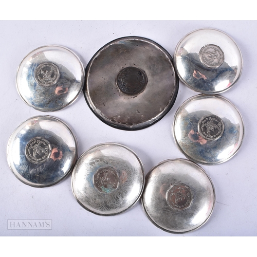 4097 - AN ISLAMIC WHITE METAL COIN INSET DISH together with six other dishes inset with Thai coins. 256 gra... 