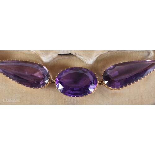 173 - A FINE VICTORIAN 15CT GOLD AND AMETHYST NECKLACE formed with graduated oval, pear and circular shape... 