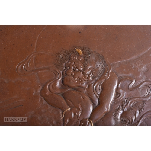 219 - A 19TH CENTURY JAPANESE MEIJI PERIOD BRONZE PLAQUE decorated in relief with a male in the clouds. 30... 