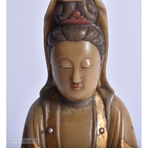 220 - A CHINESE QING DYNASTY GILDED SOAPSTONE FIGURE OF GUANYIN. 16 cm high.