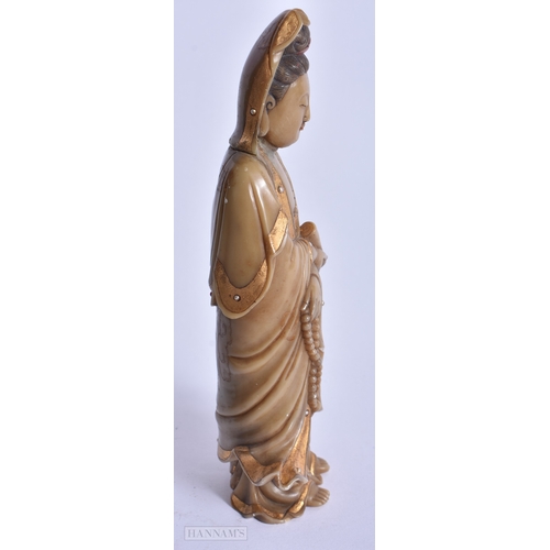 220 - A CHINESE QING DYNASTY GILDED SOAPSTONE FIGURE OF GUANYIN. 16 cm high.