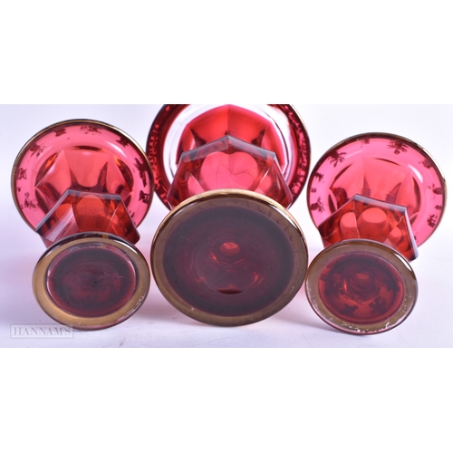 6 - A 19TH CENTURY BOHEMIAN RUBY GLASS GARNITURE painted in gilt with foliage and vines. Largest 14 cm x... 