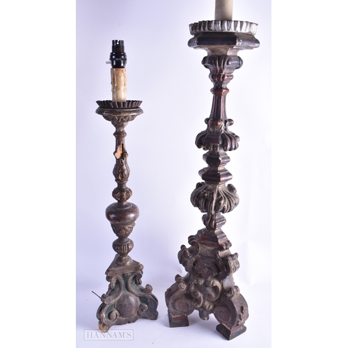 72 - TWO LARGE EARLY 18TH CENTURY CONTINENTAL LACQUERED WOOD CANDLESTICKS with scrolling rococo acanthus ... 