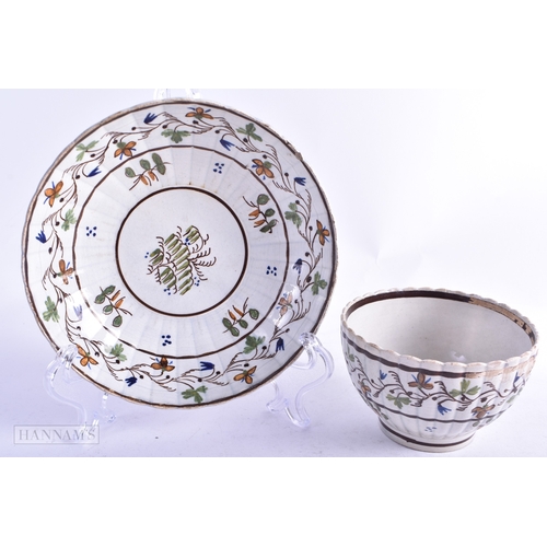 75 - AN 18TH CENTURY ENGLISH CREAMWARE TEABOWL AND SAUCER together with two Delft plates. Largest 21 cm d... 