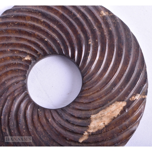 76 - AN EXTREMELY RARE CHINESE HAN DYNASTY JADE BI DISC of unusual spiralised form. 7.5 cm diameter. Note... 