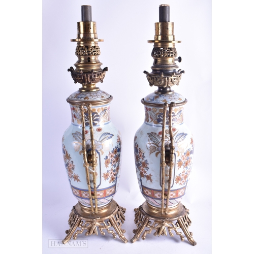 81 - A FINE PAIR OF 18TH CENTURY JAPANESE EDO PERIOD IMARI OIL LAMPS painted with a fenced garden, contai... 