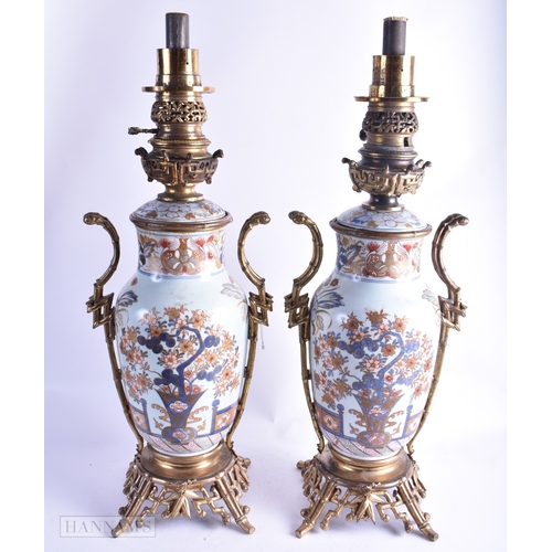 81 - A FINE PAIR OF 18TH CENTURY JAPANESE EDO PERIOD IMARI OIL LAMPS painted with a fenced garden, contai... 