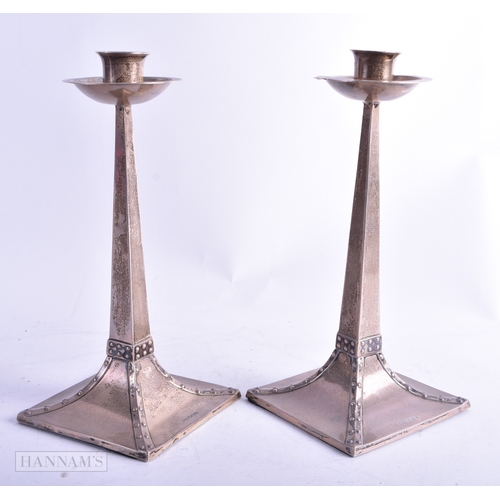 86 - A PAIR OF ARTS AND CRAFTS SILVER CANDLESTICKS. 688 grams overall. 22.5 cm high.