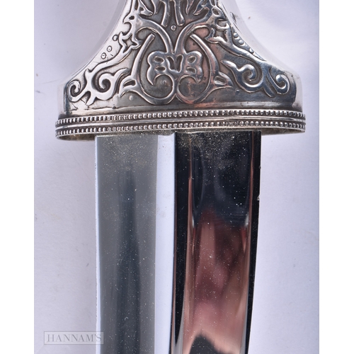 111 - A LARGE MIDDLE EASTERN SILVER OVERLAID JAMBIYA DAGGER. 28cm x 14 cm.