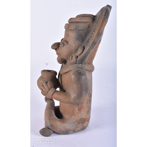 113 - A SOUTH AMERICAN POTTERY FIGURE OF A TRIBAL MALE. 24 cm high.