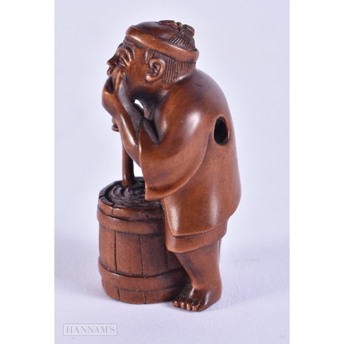 2058 - A JAPANESE CARVED WOOD NETSUKE formed as a male washing clothes. 5 cm x 2.75 cm.