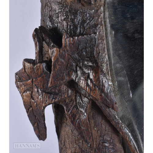 105 - A 19TH CENTURY BAVARIAN BLACK FOREST CARVED WOOD MIRROR of naturalistic form. 52 cm x 34 cm.