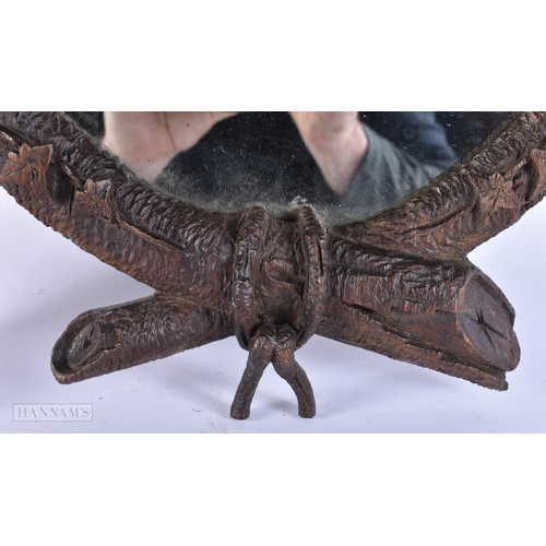 105 - A 19TH CENTURY BAVARIAN BLACK FOREST CARVED WOOD MIRROR of naturalistic form. 52 cm x 34 cm.