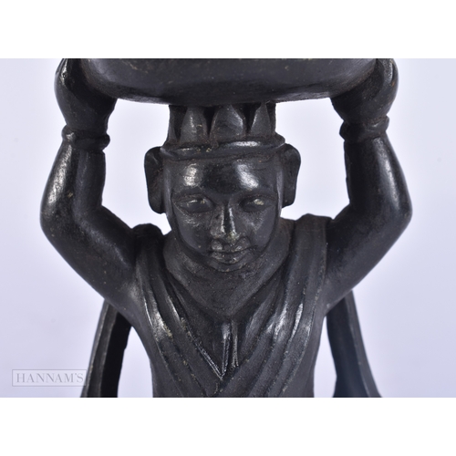 121 - A RARE 18TH/19TH CENTURY INDIAN CARVED STONE DEITY modelled holding aloft a basket inset with a figu... 