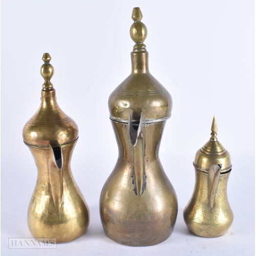 146 - FIVE ISLAMIC MIDDLE EASTERN LONG SPOUT COFFEE POT EWERS. Largest 40 cm high. (5)