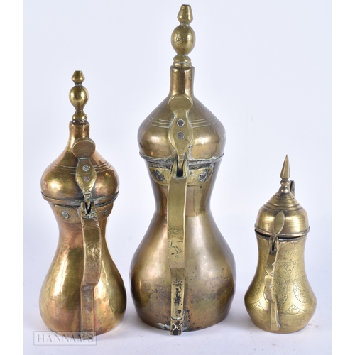 146 - FIVE ISLAMIC MIDDLE EASTERN LONG SPOUT COFFEE POT EWERS. Largest 40 cm high. (5)