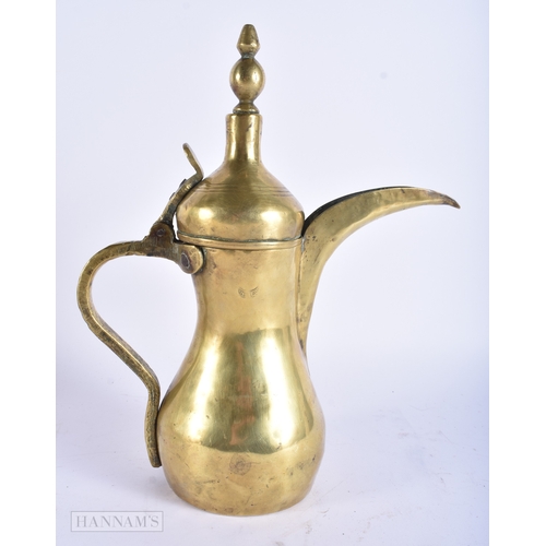27 - AN ISLAMIC MIDDLE EASTERN BRASS COFFEE POT EWER. 32 cm x 18 cm.
