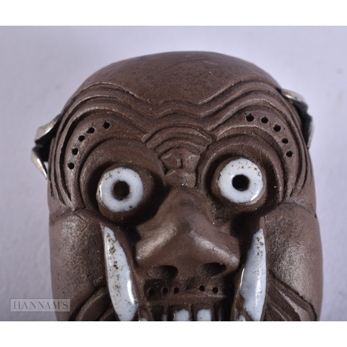 375 - AN UNUSUAL 19TH CENTURY JAPANESE MEIJI PERIOD POTTERY MASK NETSUKE. 4.5 cm x 3.5 cm.