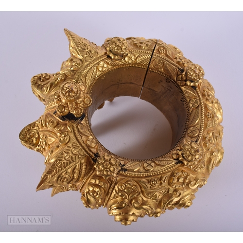 384 - A LARGE ANTIQUE INDIAN YELLOW METAL WEDDING CEREMONIAL BANGLE. 692 grams. Internal width 6.25 cm.
