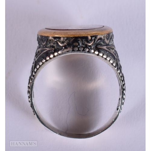 392 - AN UNUSUAL ANTIQUE ISLAMIC MIDDLE EASTERN SILVER ARABIC RING inset with a yellow metal glass cased m... 