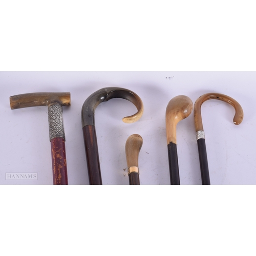 755 - THREE ANTIQUE CARVED RHINOCEROS HORN CANES together with two others. 90 cm long. (5)