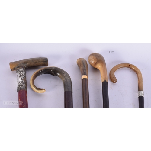 755 - THREE ANTIQUE CARVED RHINOCEROS HORN CANES together with two others. 90 cm long. (5)