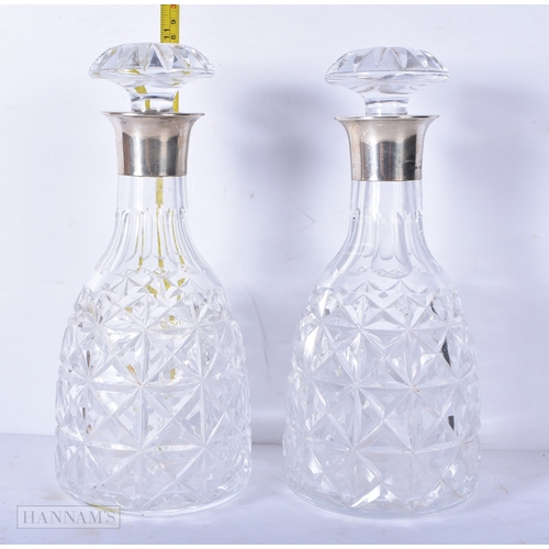 3042 - A pair of silver rimmed cut glass decanters 28cm (2)