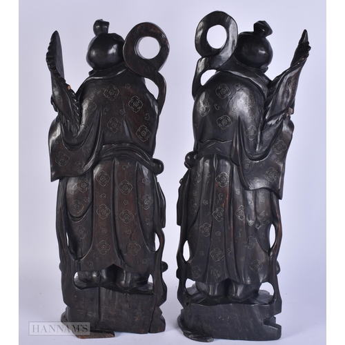 340 - A PAIR OF 19TH CENTURY CHINESE CARVED SILVER INLAID HARDWOOD FIGURES. 48 cm high.