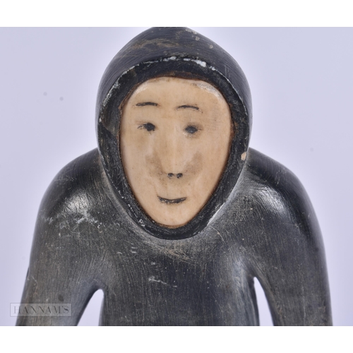 353 - AN EARLY 20TH CENTURY NORTH AMERICAN INUIT CARVED STONE FIGURE modelled as a hunter. 13 cm high.