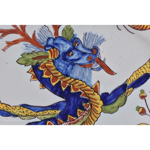 355 - AN UNUSUAL ANTIQUE FRENCH FAIENCE DRAGON PLATE. 23.5 cm wide.