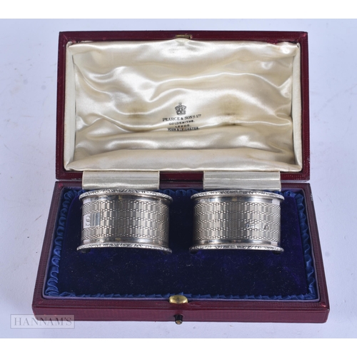465 - A PAIR OF CASED ANTIQUE SILVER NAPKIN RINGS. 70 grams. 5 cm wide.