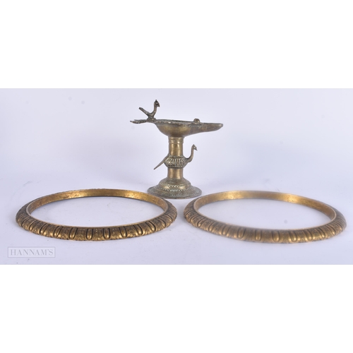 475 - AN ANTIQUE INDIAN BRONZE OIL BURNER together with two bronze mounts. Largest 25 cm wide. (3)