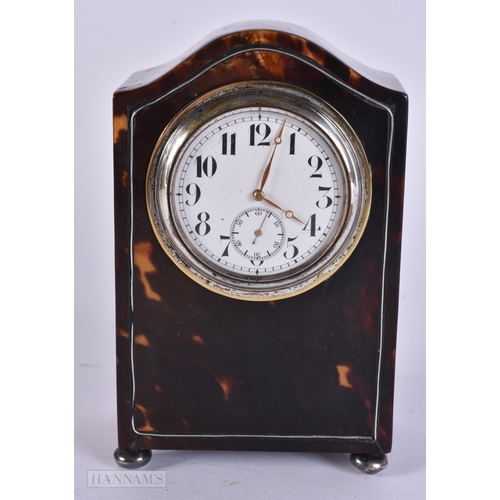 909 - A LATE VICTORIAN/EDWARDIAN SILVER MOUNTED TORTOISESHELL CLOCK with silver feet. 12 cm x 8 cm.
