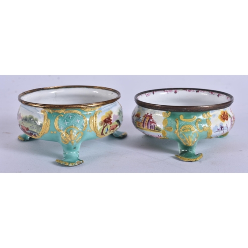 5 - AN UNUSUAL PAIR OF 18TH CENTURY BATTERSEA ENAMEL SALTS painted with landscapes. 7 cm wide.