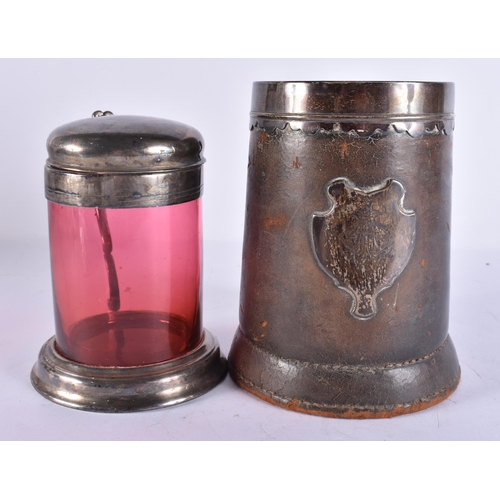 200E - AN ANTIQUE SILVER MOUNTED LEATHER TANKARD together with a smaller silver plated ruby glass tankard. ... 