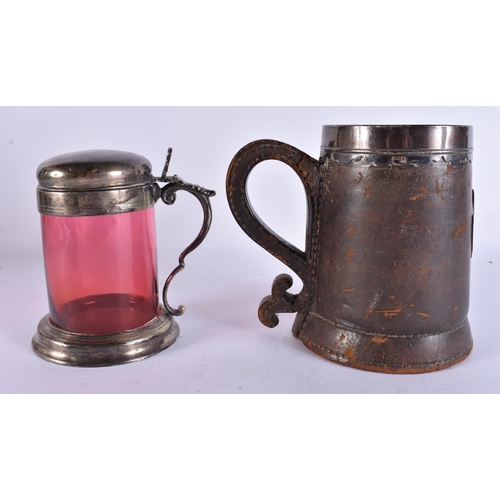 200E - AN ANTIQUE SILVER MOUNTED LEATHER TANKARD together with a smaller silver plated ruby glass tankard. ... 