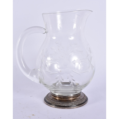 395 - A SILVER MOUNTED GLASS JUG. 17 cm high.