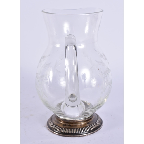 395 - A SILVER MOUNTED GLASS JUG. 17 cm high.