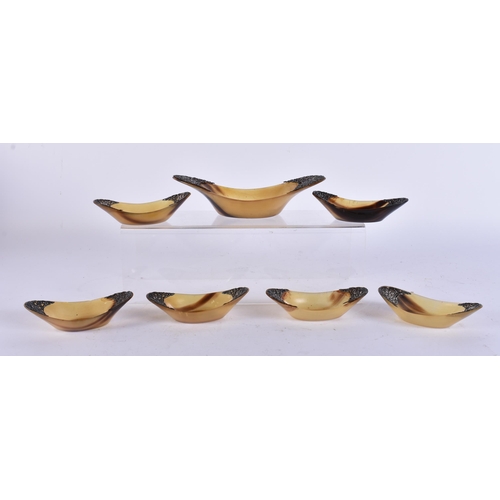 405 - A SET OF 19TH CENTURY INDIAN SILVER MOUNTED HORN BOWLS. Largest 18 cm wide. (7)