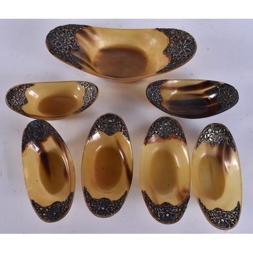 405 - A SET OF 19TH CENTURY INDIAN SILVER MOUNTED HORN BOWLS. Largest 18 cm wide. (7)