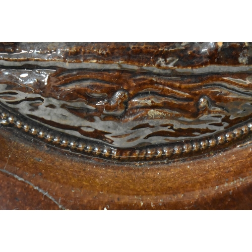 48 - AN EXTREMELY RARE ANTIQUE RUSSIAN TREACLE GLAZED POTTERY PLATE. 21.5 cm wide.