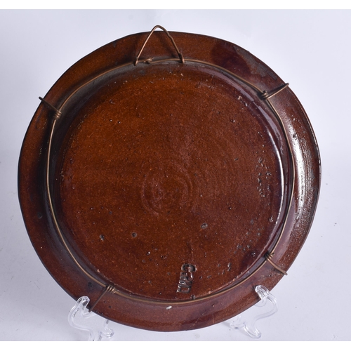 48 - AN EXTREMELY RARE ANTIQUE RUSSIAN TREACLE GLAZED POTTERY PLATE. 21.5 cm wide.