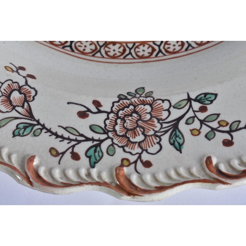 60E - A LATE 18TH/19TH CENTURY ENGLISH CREAMWARE SCALLOPED PLATE painted with an Oriental figure holding a... 