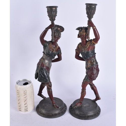 686 - A PAIR OF COLD PAINTED NATIVE AMERICAN FIGURAL CANDLESTICKS. 38 cm high.