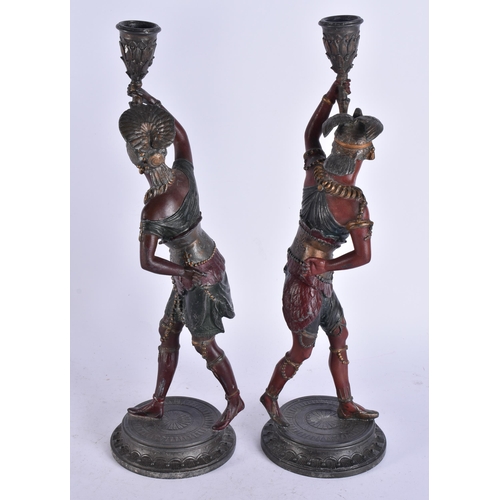 686 - A PAIR OF COLD PAINTED NATIVE AMERICAN FIGURAL CANDLESTICKS. 38 cm high.
