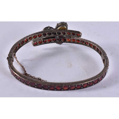 1604 - A Garnet Set Bangle.  5cm x 5.9cm, weight 16.2g