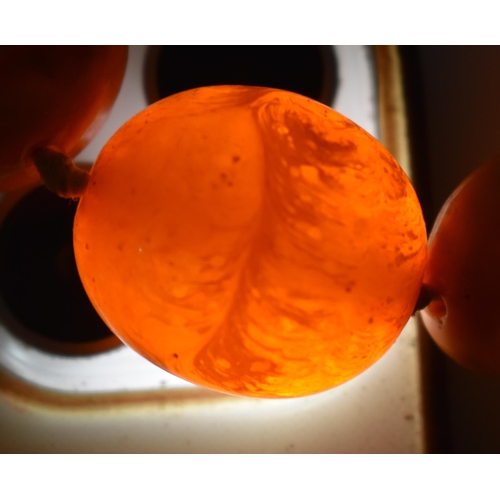 2049 - A BUTTERSCOTCH AMBER NECKLACE together with a cherry amber snuff bottle & a stone horse. Necklace 49... 