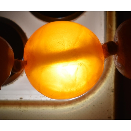 2049 - A BUTTERSCOTCH AMBER NECKLACE together with a cherry amber snuff bottle & a stone horse. Necklace 49... 