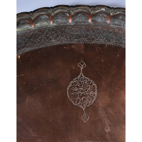 3191 - A large Middle eastern copper tray etched with Tugra and script and hammered scalloped rim 72 cm dia... 