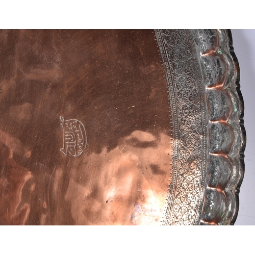 3191 - A large Middle eastern copper tray etched with Tugra and script and hammered scalloped rim 72 cm dia... 